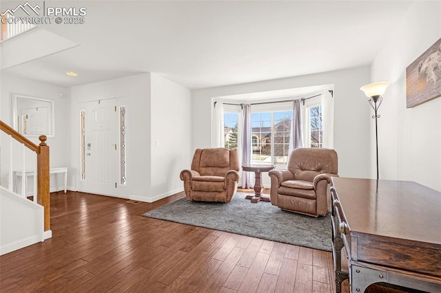 living area with stairway, wood-type flooring, and baseboards