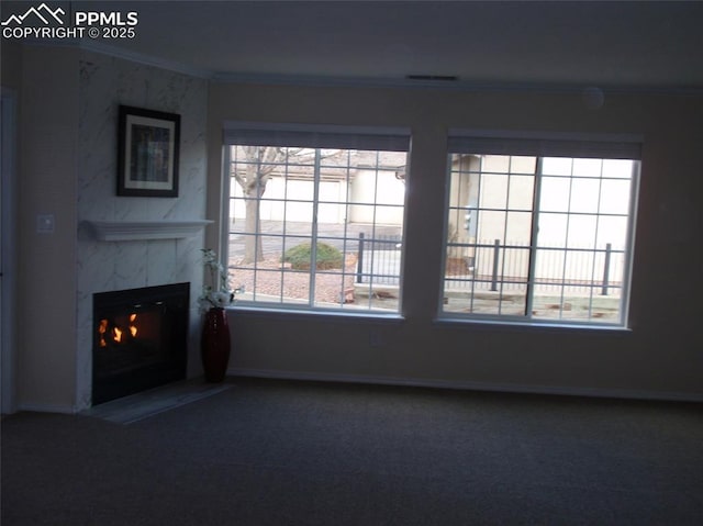 2112 Denton Grv Unit 101, Colorado Springs, CO 80919 - unfurnished living room with baseboards, ornamental molding, a fireplace, carpet flooring, and visible vents