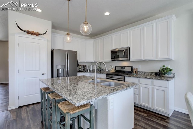 17718 Leisure Lake Dr, Monument, CO 80132 - kitchen with appliances with stainless steel finishes, a sink, white cabinets, dark wood-style flooring, and recessed lighting