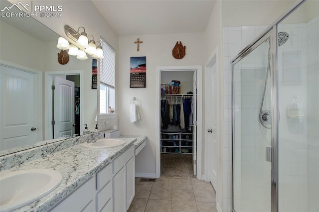 17718 Leisure Lake Dr, Monument, CO 80132 - full bath featuring a shower stall, a spacious closet, double vanity, tile patterned floors, and baseboards