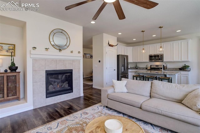 17718 Leisure Lake Dr, Monument, CO 80132 - living area with dark wood finished floors, a ceiling fan, a fireplace, recessed lighting, and baseboards