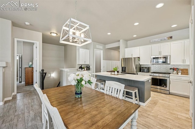 dining area with light wood-style flooring, recessed lighting, and a toaster