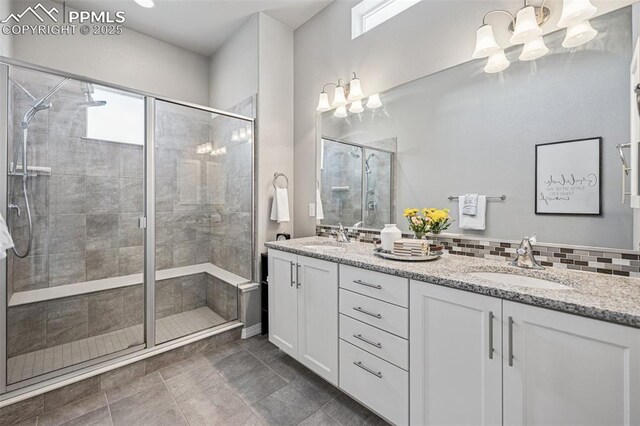 full bathroom with a sink, an inviting chandelier, and a stall shower