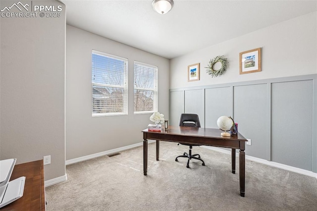 carpeted home office featuring wainscoting, a decorative wall, and visible vents