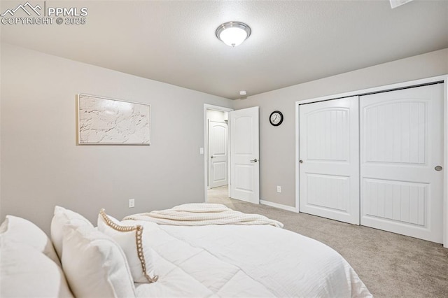 bedroom featuring baseboards, a closet, and light carpet