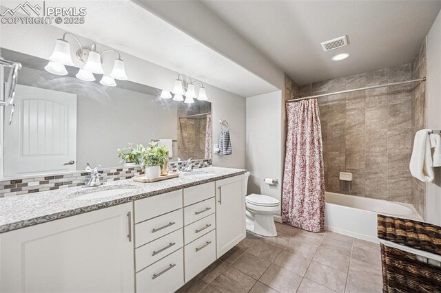 bathroom with toilet, a sink, visible vents, double vanity, and a notable chandelier