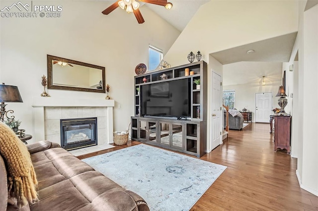 living area featuring a ceiling fan, wood finished floors, and a wealth of natural light