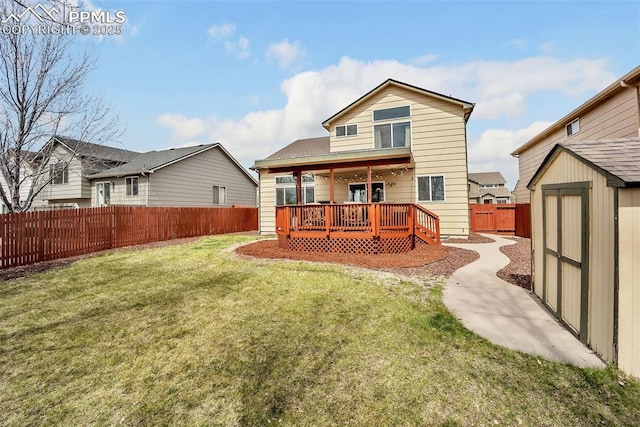 back of house featuring a shed, a lawn, a fenced backyard, an outdoor structure, and a wooden deck