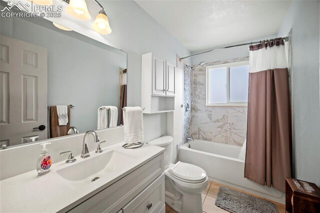 full bathroom featuring toilet, vanity, tile patterned floors, and shower / tub combo with curtain