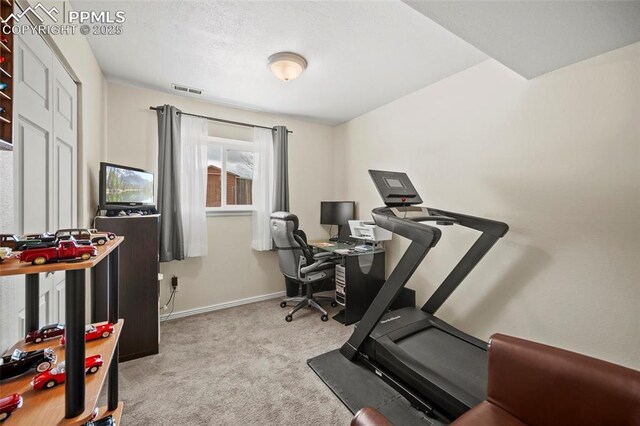 exercise area featuring baseboards, visible vents, and carpet