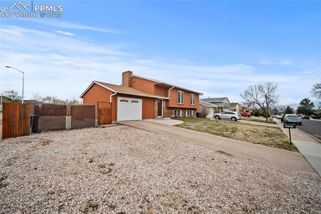 view of front of property featuring a gate, concrete driveway, stucco siding, an attached garage, and fence