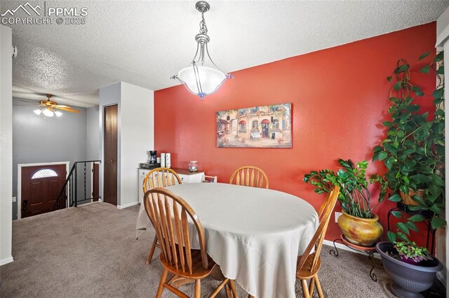 dining space featuring carpet, baseboards, ceiling fan, and a textured ceiling