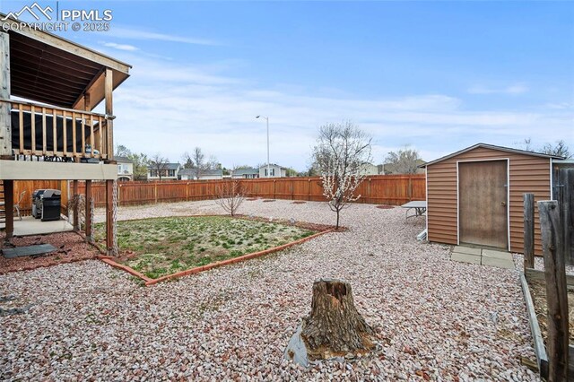 view of yard with an outbuilding, a storage unit, a fenced backyard, and a patio area