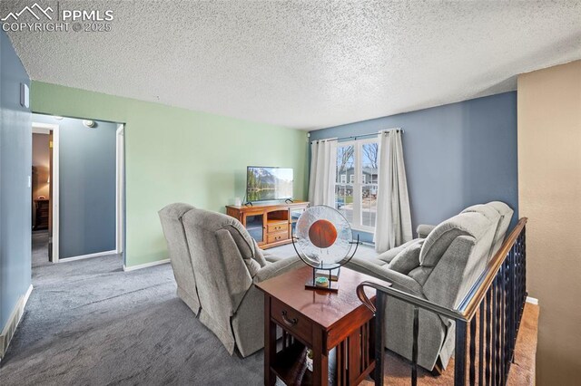 carpeted living room with baseboards and a textured ceiling