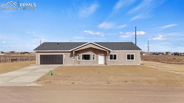 ranch-style house featuring a garage, a shingled roof, stucco siding, and concrete driveway