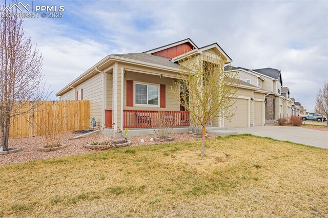 9712 Wando Dr, Colorado Springs, CO 80925 - view of front of house featuring fence, concrete driveway, a porch, and a front yard