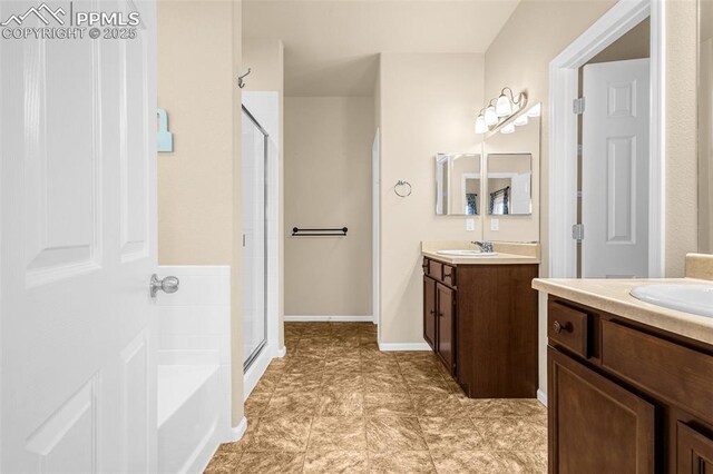 9712 Wando Dr, Colorado Springs, CO 80925 - bathroom featuring a bath, baseboards, a shower stall, and two vanities
