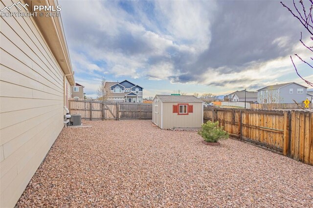 9712 Wando Dr, Colorado Springs, CO 80925 - view of yard featuring central air condition unit, a storage shed, a fenced backyard, a residential view, and an outdoor structure