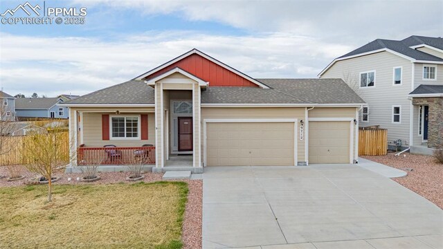 9712 Wando Dr, Colorado Springs, CO 80925 - view of front of house featuring roof with shingles, an attached garage, driveway, a front lawn, and a porch