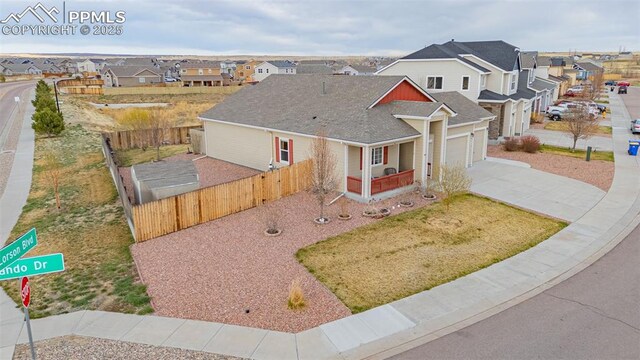 9712 Wando Dr, Colorado Springs, CO 80925 - view of front of home featuring a residential view, concrete driveway, a shingled roof, and fence