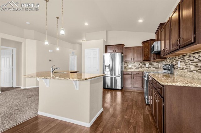 9712 Wando Dr, Colorado Springs, CO 80925 - kitchen with an island with sink, lofted ceiling, tasteful backsplash, and stainless steel appliances