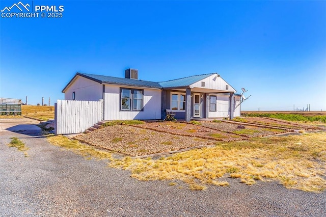 2801 Lime Rd, Pueblo, CO 81006 - view of front of house with metal roof, fence, and a chimney