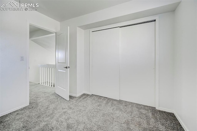 unfurnished bedroom featuring a closet, baseboards, and carpet floors
