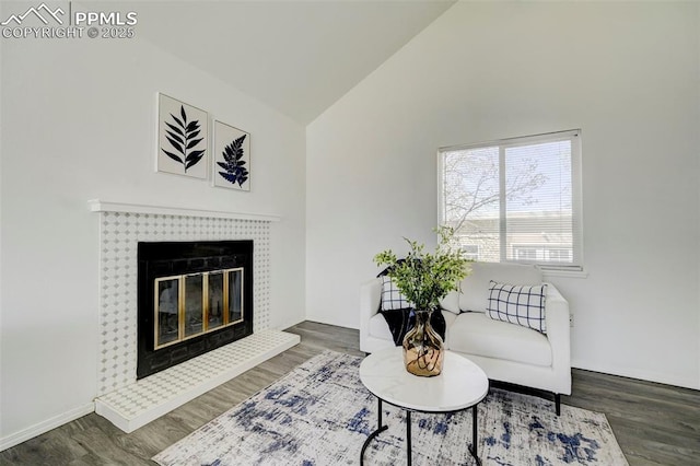 living area with a fireplace, wood finished floors, and lofted ceiling