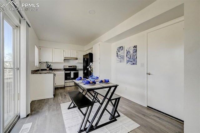 dining room featuring visible vents, baseboards, and wood finished floors