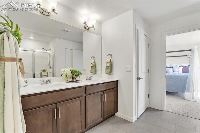 15833 Little Bluestem Rd, Monument, CO 80132 - full bathroom featuring double vanity, visible vents, a sink, and a stall shower