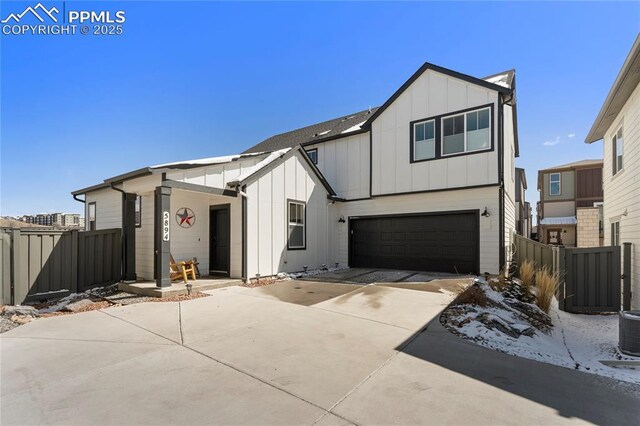 5894 Spring Breeze Dr, Colorado Springs, CO 80923 - modern farmhouse with board and batten siding, concrete driveway, a garage, and fence