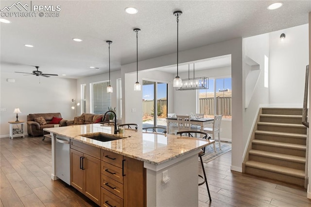 5894 Spring Breeze Dr, Colorado Springs, CO 80923 - kitchen with a sink, open floor plan, dark wood-style flooring, a center island with sink, and stainless steel dishwasher