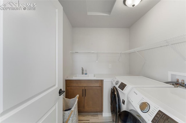 5894 Spring Breeze Dr, Colorado Springs, CO 80923 - laundry area with light wood-style flooring, independent washer and dryer, a sink, and cabinet space