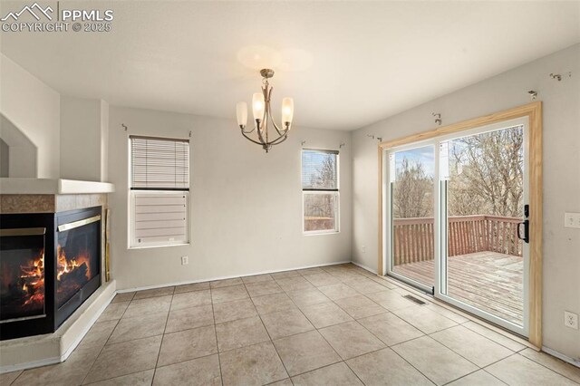 795 Ridgebury Pl, Fountain, CO 80817 - unfurnished dining area with baseboards, an inviting chandelier, tile patterned floors, a fireplace, and visible vents