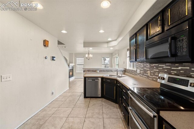 795 Ridgebury Pl, Fountain, CO 80817 - kitchen featuring a notable chandelier, a sink, appliances with stainless steel finishes, a peninsula, and decorative backsplash