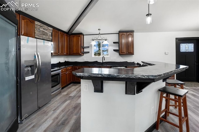 kitchen featuring a kitchen breakfast bar, dark countertops, open shelves, light wood finished floors, and stainless steel appliances