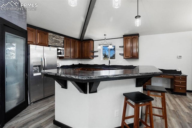 kitchen with a breakfast bar area, appliances with stainless steel finishes, and light wood finished floors