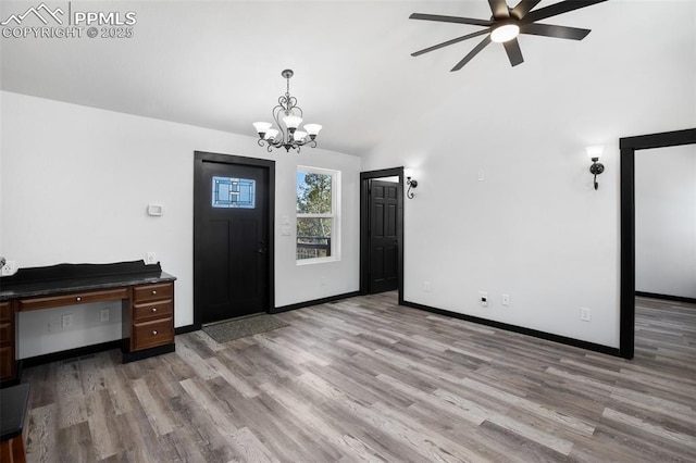 entrance foyer featuring baseboards, vaulted ceiling, ceiling fan with notable chandelier, and light wood-type flooring