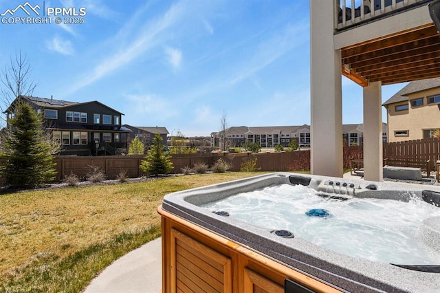 view of yard featuring a fenced backyard, a residential view, and a hot tub