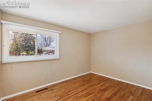 2928 Drakestone Dr, Colorado Springs, CO 80909 - empty room featuring visible vents, baseboards, and wood finished floors