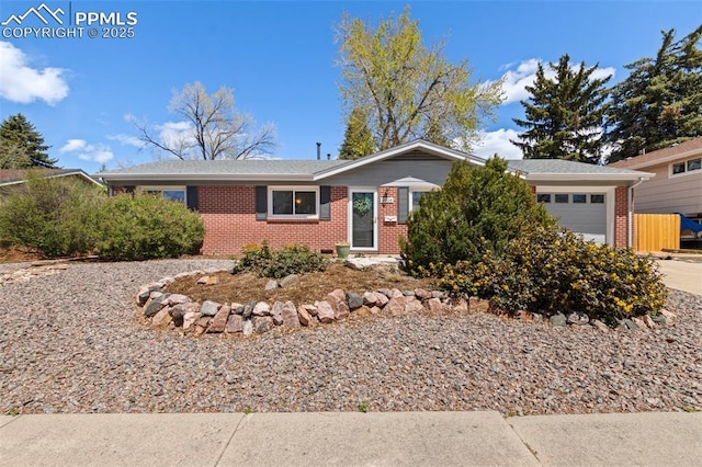 2928 Drakestone Dr, Colorado Springs, CO 80909 - ranch-style house featuring brick siding, an attached garage, and driveway