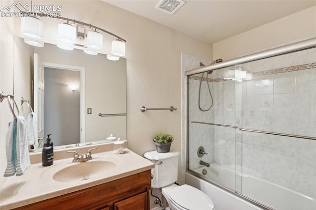 2928 Drakestone Dr, Colorado Springs, CO 80909 - full bathroom with visible vents, combined bath / shower with glass door, toilet, and vanity