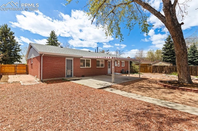 2928 Drakestone Dr, Colorado Springs, CO 80909 - back of property featuring a fenced backyard, a patio area, and brick siding