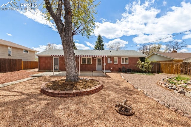 2928 Drakestone Dr, Colorado Springs, CO 80909 - rear view of house featuring a fenced backyard, a patio area, and brick siding