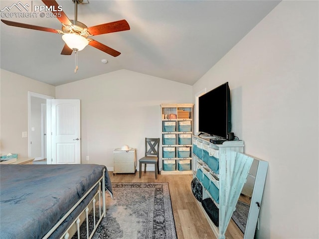 bedroom featuring a ceiling fan, lofted ceiling, and wood finished floors