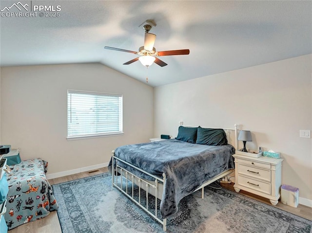 bedroom featuring baseboards, lofted ceiling, ceiling fan, and wood finished floors
