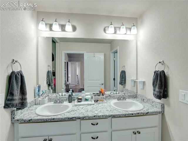 full bathroom with double vanity and a sink