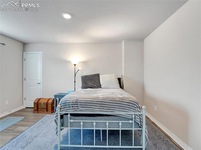 bedroom featuring baseboards and wood finished floors