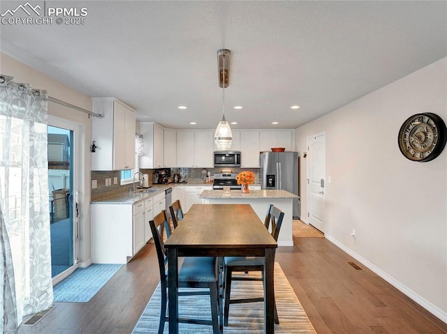 dining room with baseboards, dark wood-style floors, visible vents, and recessed lighting