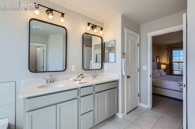 bathroom with a sink, visible vents, double vanity, and tile patterned flooring